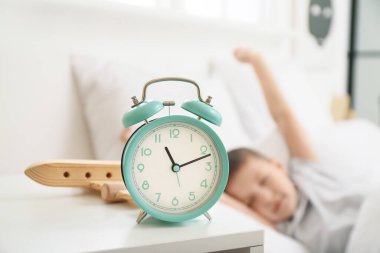 Yatak odasındaki uykucu küçük çocuğun çalar saati.
