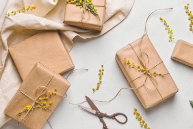 Işık arkaplan üzerinde mimoza dalları olan hediye kutuları