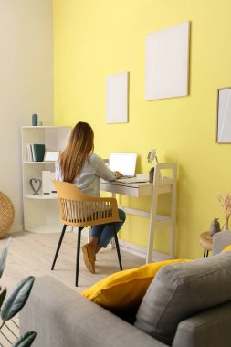 Evde dizüstü bilgisayarla çalışan bir kadın.