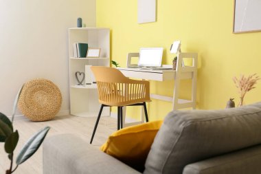 Ofisinde dizüstü bilgisayarı olan şık bir iş yeri.