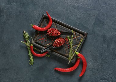 Kırmızı biberli kaşıklar ve koyu arkaplanda kırmızı biber.