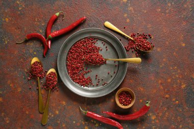 Grunge arka planında kırmızı biberli kaşık ve tabak