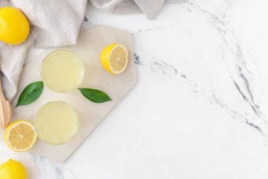 Taze limonlar ve arka planda bir bardak meyve suyu.