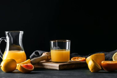 Koyu arkaplanda bir bardak portakal suyu