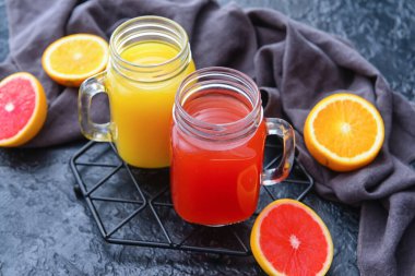 Renkli arka planda turuncu ve greyfurt suyu kavanozları