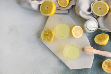 Taze limonlar ve arka planda bir bardak meyve suyu.