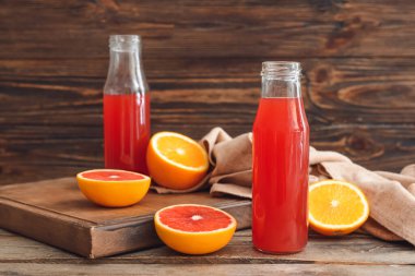 Ahşap arka planda bir şişe greyfurt suyu.