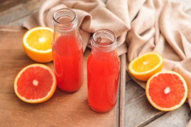 Ahşap arka planda bir şişe greyfurt suyu.