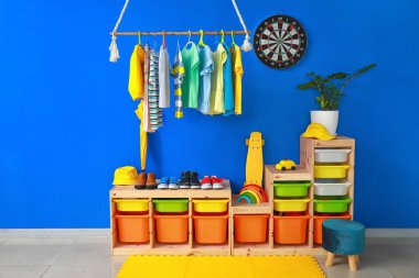 Çocuk odasının içinde kıyafetlerle dizilin.