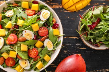 Koyu ahşap arka planda taze mango salatası.