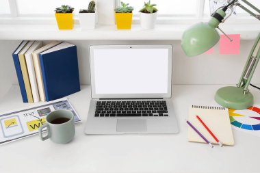 Ofisinde dizüstü bilgisayarı olan şık bir iş yeri.