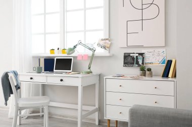 Ofisinde dizüstü bilgisayarı olan şık bir iş yeri.