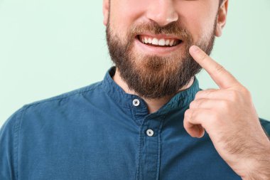 Renkli arka planda gülümseyen genç adam, yakın plan