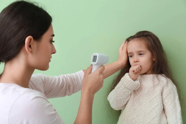 Mujer Midiendo Temperatura Pequeña Hija Enferma Gripe Contra Fondo Color — Foto de Stock