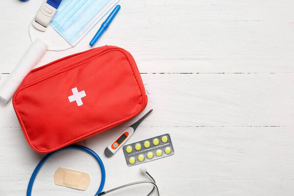 First aid kit on white wooden background