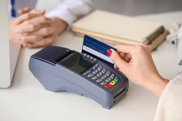 Patient paying for consultation in clinic via terminal, closeup