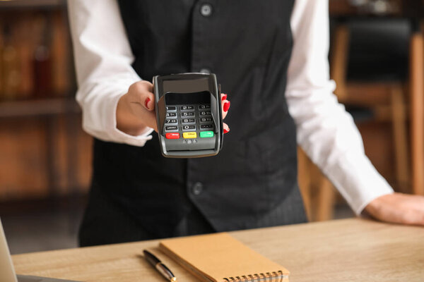 Waiter with payment terminal in cafe, closeup