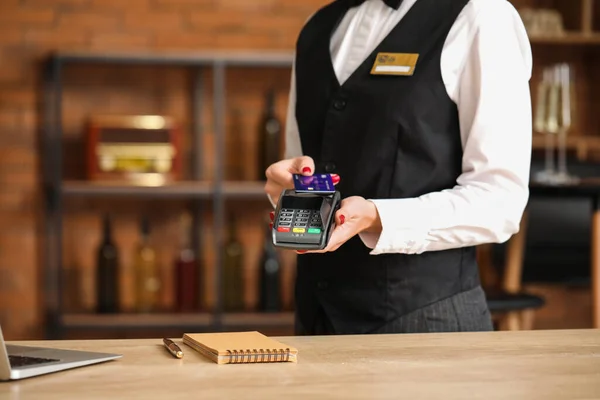 Waiter with payment terminal in cafe