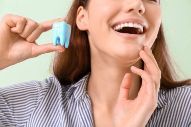 Renkli arka planda plastik dişi olan güzel bir genç kadın. Yakın plan.