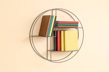 Renkli duvarda kitap asılı raflar