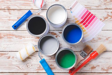 Hafif ahşap arka planda boya, fırça, rulo ve palet örnekleri