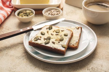 Hafif arka planda taze ekmek, tereyağı ve tohum dilimleri ile tabaka, yakın plan