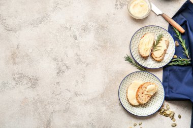 Açık arkaplanda taze ekmek, tereyağı ve biberiye tabakları