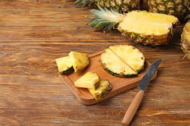 Ahşap arka planda kesilmiş taze ananas tahtası.