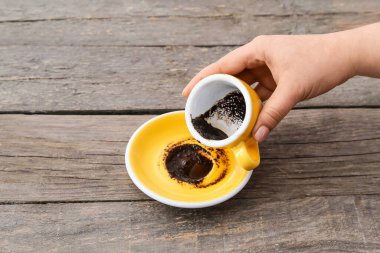 Ahşap masada kahve falı bakan bir kadın.