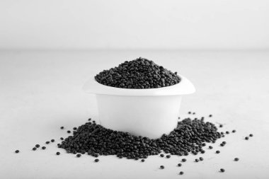 Açık arkaplanda siyah mercimek kasesi