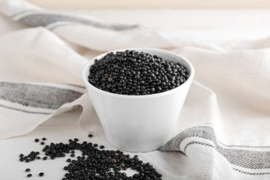 Açık arkaplanda siyah mercimek kasesi