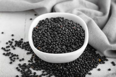 Açık arkaplanda siyah mercimek kasesi