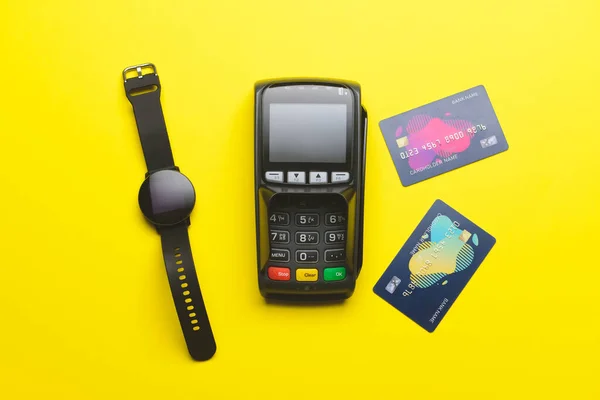 带信用卡和彩色背景智能手表的支付终端 — 图库照片