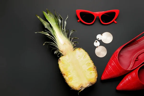 Pineapple with female accessories on dark background