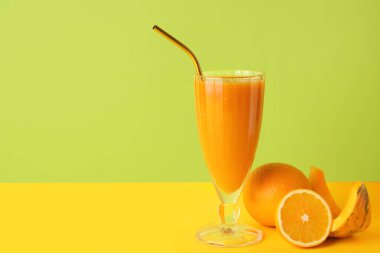 Bir bardak sağlıklı meyve püresi ve arka planda bulunan malzemeler.