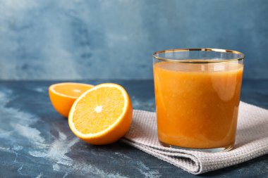 Renkli arkaplanda bir bardak portakal suyu.