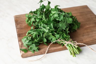 Beyaz arkaplanda taze kişniş bulunan tahta