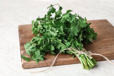 Beyaz arkaplanda taze kişniş bulunan tahta