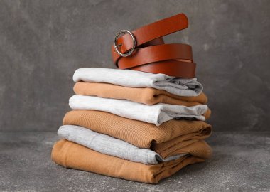 Arkaplanda kemer olan şık kıyafetler yığını