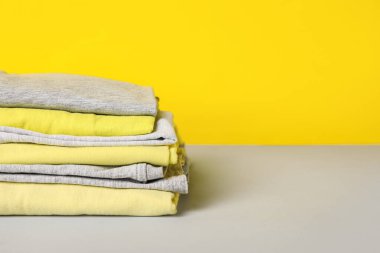 Renkli arka planda şık kıyafet yığını