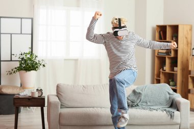 Evde VR gözlüklü genç adam var.