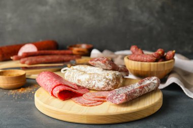 Koyu arkaplanda farklı sosisler olan tahta