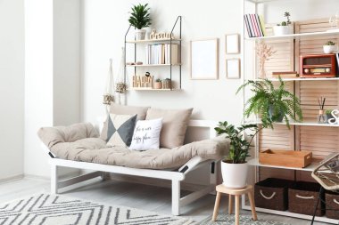 Kanepesi ve raf ünitesi olan modern oturma odasının içinde.