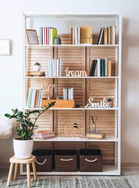 Odanın içinde kitap ve dekor olan raf ünitesi