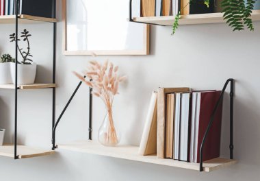 Raflarda kitaplar ve dekorasyon asılı.