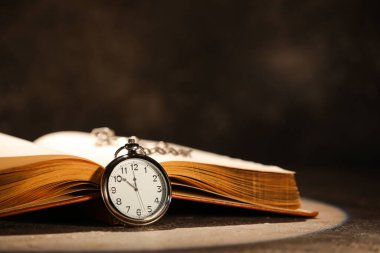 Koyu arkaplanda saati olan eski kitabı aç, kapat