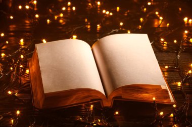 Bulanık ışıklara karşı masada eski kitabı aç