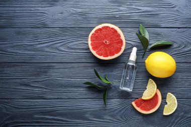 C vitamini ve koyu ahşap arka planda turunçgil meyveli bir şişe.