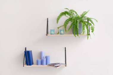 Işık duvarında yanan mumlar asılı raflar.