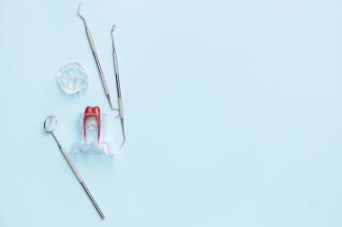 Dişçi araçları ve diş modelinin renk arkaplanı